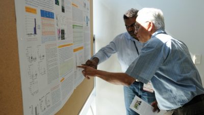Venumadhav Janganati (background), a post-doctoral fellow in the Department of Pharmaceutical Sciences, explains his research on anti-leukemia drugs.
