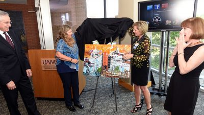 Couple smile as painting is unveiled