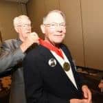 Dr. Carl Weber, COP '67 (center), has his Golden Graduate medallion draped by J.R. Ritchey.