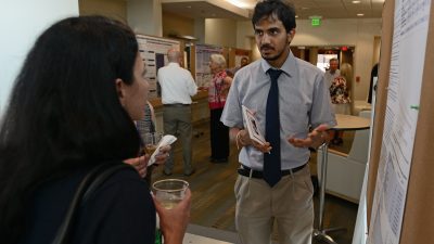 Student at poster talking to others