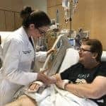 Anna Privratsky, D.O., checks on her patient and former professor Todd Maxson, M.D.
