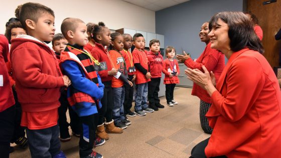 UAMS Interim Chancellor Stephanie Gardner, Pharm.D., Ed.D. (right) claps along with caroling preschoolers from Kennedy Head Start school, Room 1.