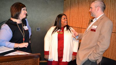 ohn Kirtley, right, talks with Laura Haywood, left and Lanita White, center, before making a presentation at the Pharmacy Update conference.