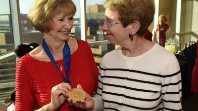 Jean C. McSweeney, Ph.D., R.N., professor, associate dean for research and co-director of the Ph.D. program in the UAMS College of Nursing, shows off the medallion from her investiture in the Women's Cardiovascular Health Professorship to Jeannette M. Shorey II, M.D., associate dean for faculty affairs in the UAMS College of Medicine and associate provost for faculty.