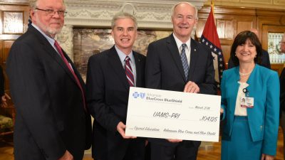 Group posing with check