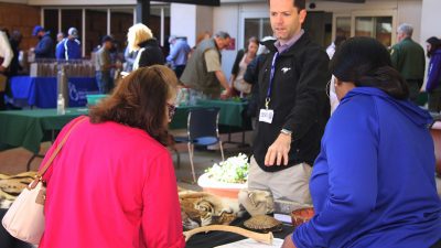 Two UAMS employees view the Little Rock Zoo's table at Earth Day on April 19, and learn about opportunities to volunteer and help out.