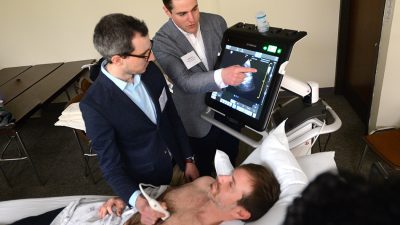 Kidney Con attendees practice using ultrasound technology with help from a standardized patient during a workshop.