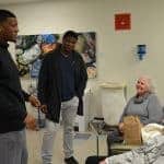 Heisman Trophy winner and Tampa Bay Buccaneer Jameis Winston (left) and Denver Bronco Clinton McDonald visit with UAMS Cancer Institute patient Cyrus B. Davis and his wife.
