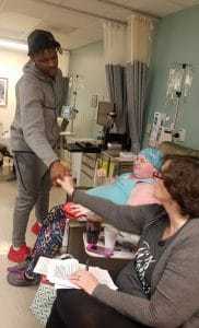 Demetrius Harris, of the Kansas City Chiefs, greets patient Weatherly Wolfe (center) and her mom, Zann Jordan.