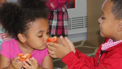 Children smelling tomato
