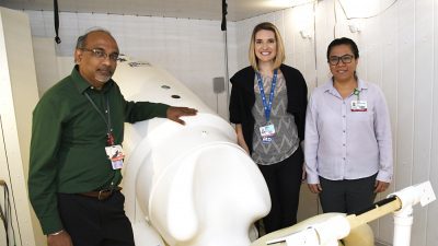 Hari Eswaran, Ph.D., Jessica Coker, M.D., center, and Diana Escalona-Vargas, Ph.D., stand next to the SARA imaging device. They completed a pilot study that determined the SARA can be used to assess the health of fetuses exposed buprenorphine.