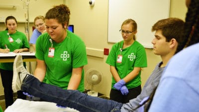 MASH students visiting the UAMS Simulation Center roleplay diagnosing a stroke patient through the AR SAVES network.