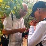 Cesar Compadre, left, and Dean Keith Olsen examine and discuss a medicinal plant growing in the Bolivian countryside.