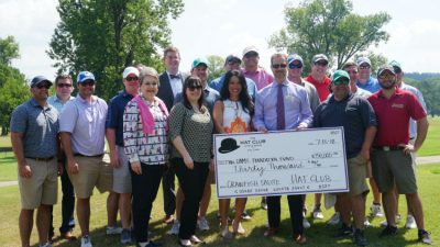 Close to two dozen Hat Club members collectively presented a check July 13 to UAMS Consortium board members.