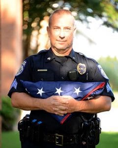 Sgt. Greg Oginski of the UAMS Police Department holds the U.S. flag.