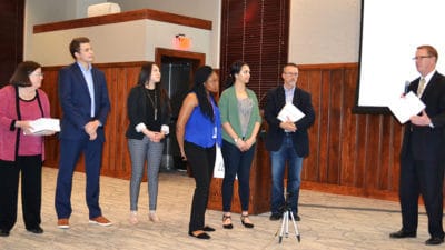 Nancy Gray, far left, gets ready to present prizes to the winning team at the Health Sciences Entrepreneurship Boot Camp in May.
