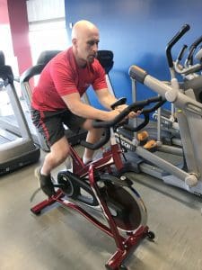 Adam Carter, fitness coordinator in the UAMS Fitness Center, takes the center's new BH Fitness LK 500IC commercial spin bike for a spin.