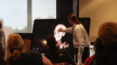 Teaching with Technology participants look on as Kevin D. Phelan, Ph.D., co-director of the Division of Clinical Anatomy, shows off the division's new Sectra Table.