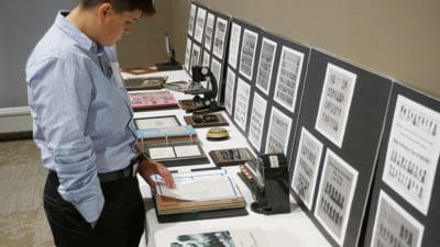 Attendees at the College of Health Professions luncheon during Alumni Weekend perused photo albums showing 100 years of Medical Laboratory Sciences at UAMS.