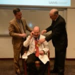 Seth Berney, M.D., receives his commemorative medallion from Chancellor Cam Patterson, M.D., MBA, and College of Medicine Dean Christopher T. Westfall, M.D.