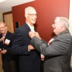 Jack Blackshear Jr., M.D., COM '68 (at right), pins a button on George Fielder Jr., M.D., COM '68 at the Friday night welcome reception.