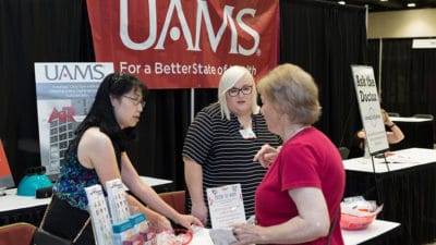 UAMS staff visit with one of the attendees at the Senior Expo at the Statehouse Convention Center.