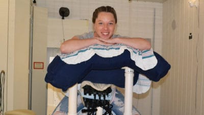 Shyanne Chisum gets into a comfortable position before the SARA 2.0 technology that she is helping to test is used.