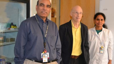 Srinivas Ayyadevara, left, Robert Shmookler Reis and research associate Ramani Alla stop for a photo in their UAMS Donald W. Reynolds Institute lab.