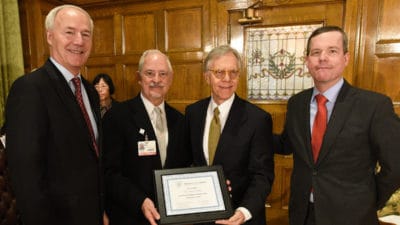 UAMS researcher Clint Kilts, Ph.D., second from left, receives a certificate naming him an Arkansas Research Alliance Fellow. Gov. Asa Hutchinson, left, ARA CEO Jerry Adams, third from left, and UAMS Chancellor Cam Patterson congratulate Kilts on receiving the honor.