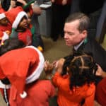 UAMS Chancellor Cam Patterson greets students from Head Start Sherwood, who came to carol on campus.