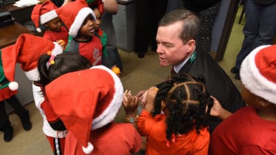 UAMS Chancellor Cam Patterson greets students from Head Start Sherwood, who came to carol on campus.