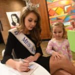 Miss Arkansas 2018 Claudia Raffo signs an autograph for a fan. Raffo and four former Miss Arkansas titleholders were special guests at the UAMS Alumni Association holiday open house.