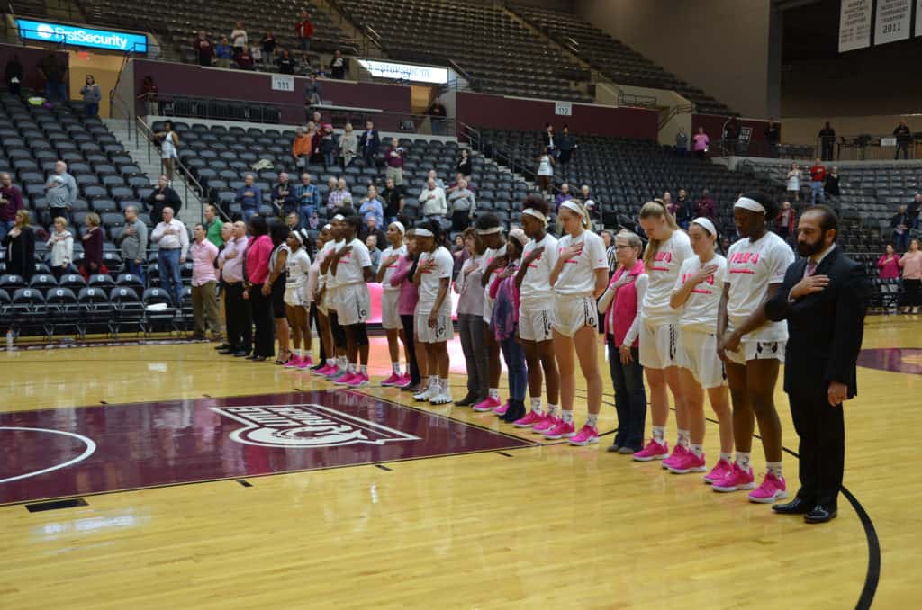 UAMS breast cancer survivors and Issam Makhoul, M.D., joined the UALR women's basketball team on the court for the national anthem.