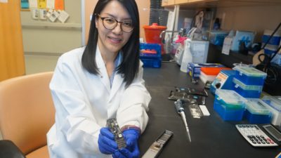 Thidathip (Tip) Wongsurawat, Ph.D., with the hand-held nanopore device used for the first time to sequence multiple viruses.