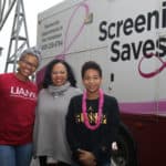 Expo volunteers (from left) Margaret Woods, Ronda Henry-Tillman, M.D., and her son Anders Tillman in front of the UAMS MammoVan.