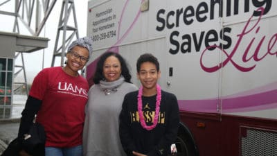 Expo volunteers (from left) Margaret Woods, Ronda Henry-Tillman, M.D., and her son Anders Tillman in front of the UAMS MammoVan.