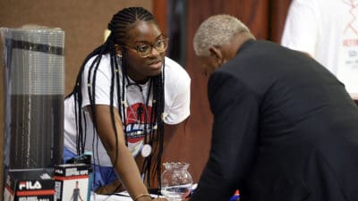 A March Man-ness Health Event volunteer talks with one of the attendees at one of the event's information tables.