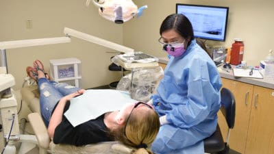Ashtyn Sturch, a senior in the Dental Hygiene program, examines a patient at the 12th Street Health & Wellness Center.