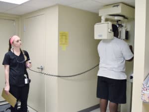 Avery Pruitt, a junior in the Dental Hygiene program, gets X-rays of a patient's mouth. The 12th Street clinic provides basic dental screenings for patients, many of whom have no access to dental care.
