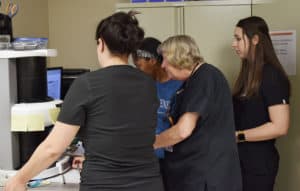Marcia Wheeler, D.D.S., consults with dental hygiene students on a patient's X-rays. Wheeler works Monday and Wednesdays at the free clinic.