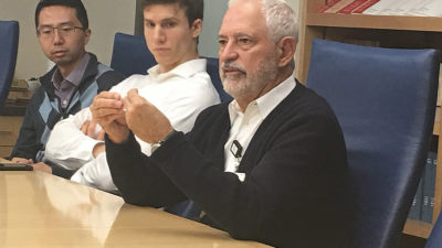 Dr. Kilts speaking at table, two others look on