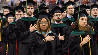 Sharanda Williams (center), director of Academic Affairs in the UAMS College of Medicine, stands as marshal with students ready to receive their diplomas.