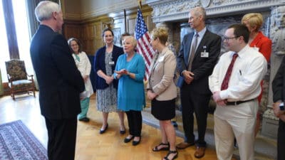 Betty Fortner, a cancer survivor and clinical trial participant, briefly told her story to Gov. Asa Hutchinson and UAMS and ACRI research leaders during a photo opportunity for Clinical Trials Day.