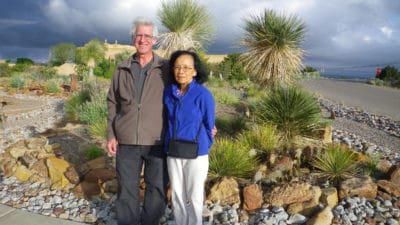 Portrait of Gerry Dienel and Nancy Cruz outside, surrounded by desert plants