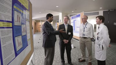 Doctors near scientific poster