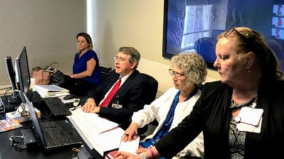 On the UAMS main campus in Little Rock, T. Glenn Pait, M.D., second from left, consults with a spine patient at one the UAMS Regional Campus locations