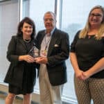 Larry Lichty (center) is this year’s Volunteer of the Year, honored for his work with the Connections Team serving international patients. Congratulating him on his award are Jane Corley, director of international patient services (left) and Chrissy Adams, international finance manager.