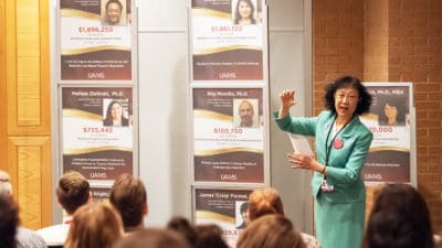 Shuk-Mei Ho, Ph.D., UAMS vice chancellor for research, presents two new displays celebrating recent grants to UAMS researchers.