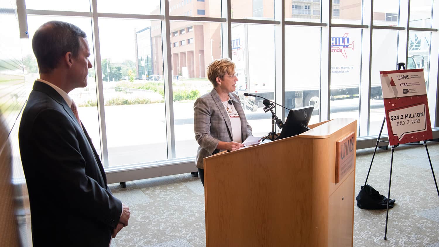 UAMS Chancellor Cam Patterson, left, listens to Laura James, M.D., director of the UAMS Translational Research Institute after both of them announced $24.2 million in new funding for the institute.