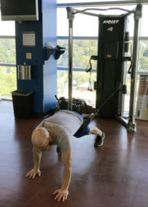 Adam Carter demonstrates a bear crawl exercise on the new Mi6 Cable Training station in the Fitness Center. The bear crawl is excellent for improving core strength, hip stability and hip mobility.